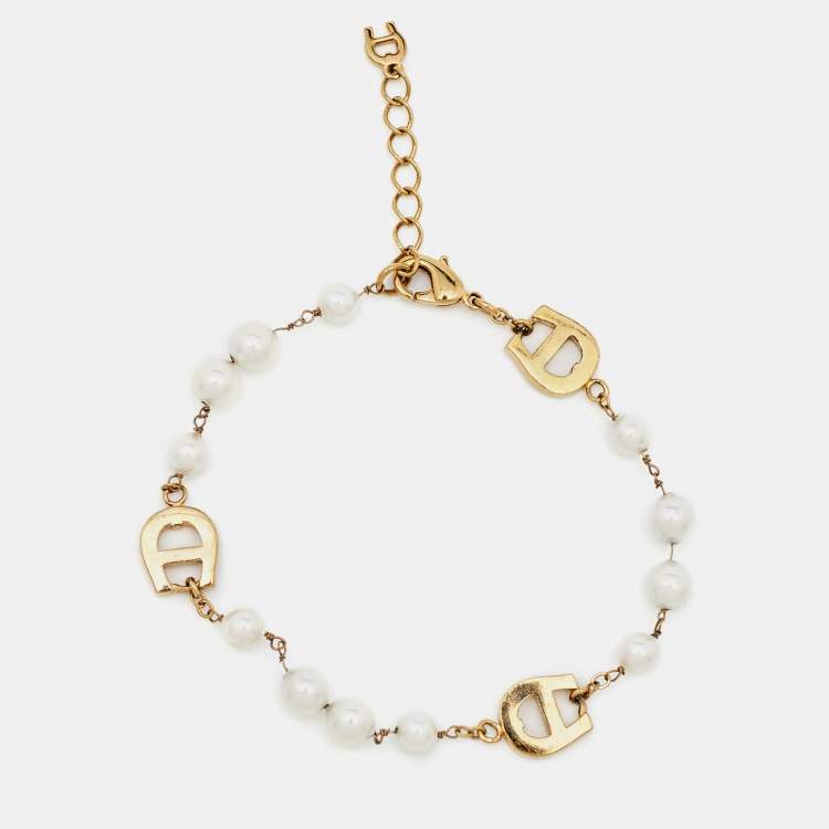 Pre Owned Aigner Gold Tone Crystal Logo Faux Pearl Station Bracelet