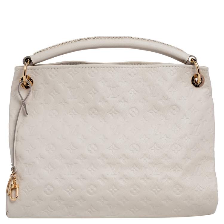 Experience the enchanting beauty of the Louis Vuitton Artsy MM Neige Monogram  Empreinte Leather Bag as you gracefully drape it over your…