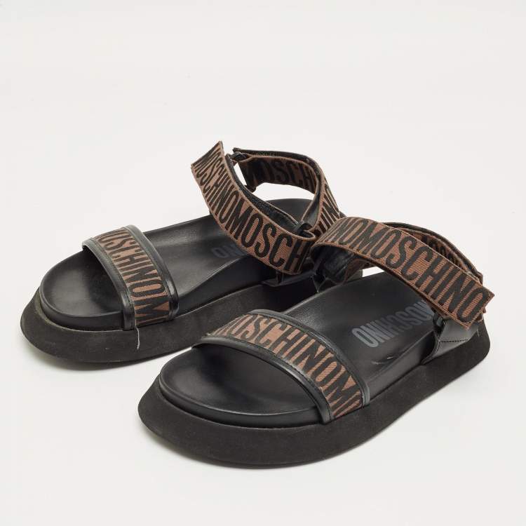 Pre Owned Moschino Brown/Black Canvas Logo Ankle Strap Flat Sandals Size 37