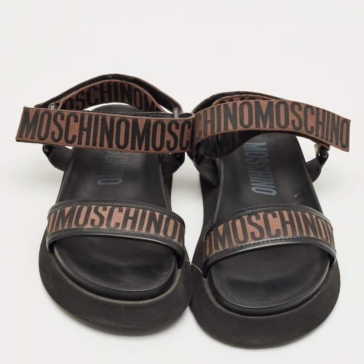 Pre Owned Moschino Brown/Black Canvas Logo Ankle Strap Flat Sandals Size 37