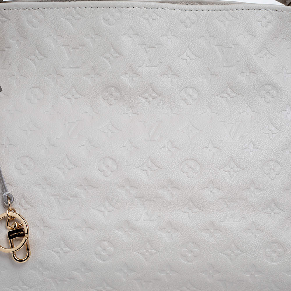 Experience the enchanting beauty of the Louis Vuitton Artsy MM Neige  Monogram Empreinte Leather Bag as you gracefully drape it over your…