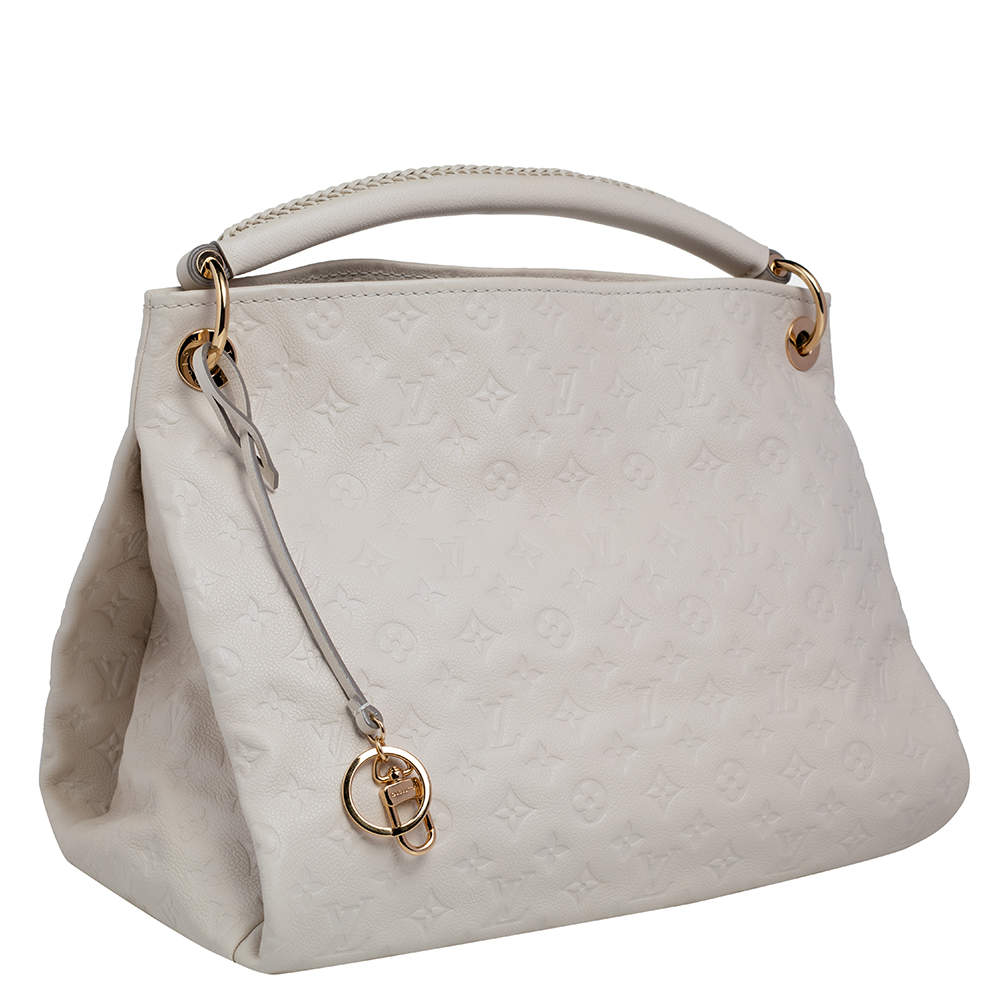 Experience the enchanting beauty of the Louis Vuitton Artsy MM Neige Monogram  Empreinte Leather Bag as you gracefully drape it over your…