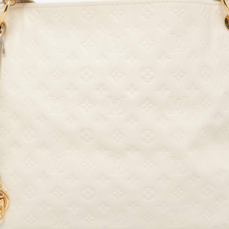 Experience the enchanting beauty of the Louis Vuitton Artsy MM Neige  Monogram Empreinte Leather Bag as you gracefully drape it over your…