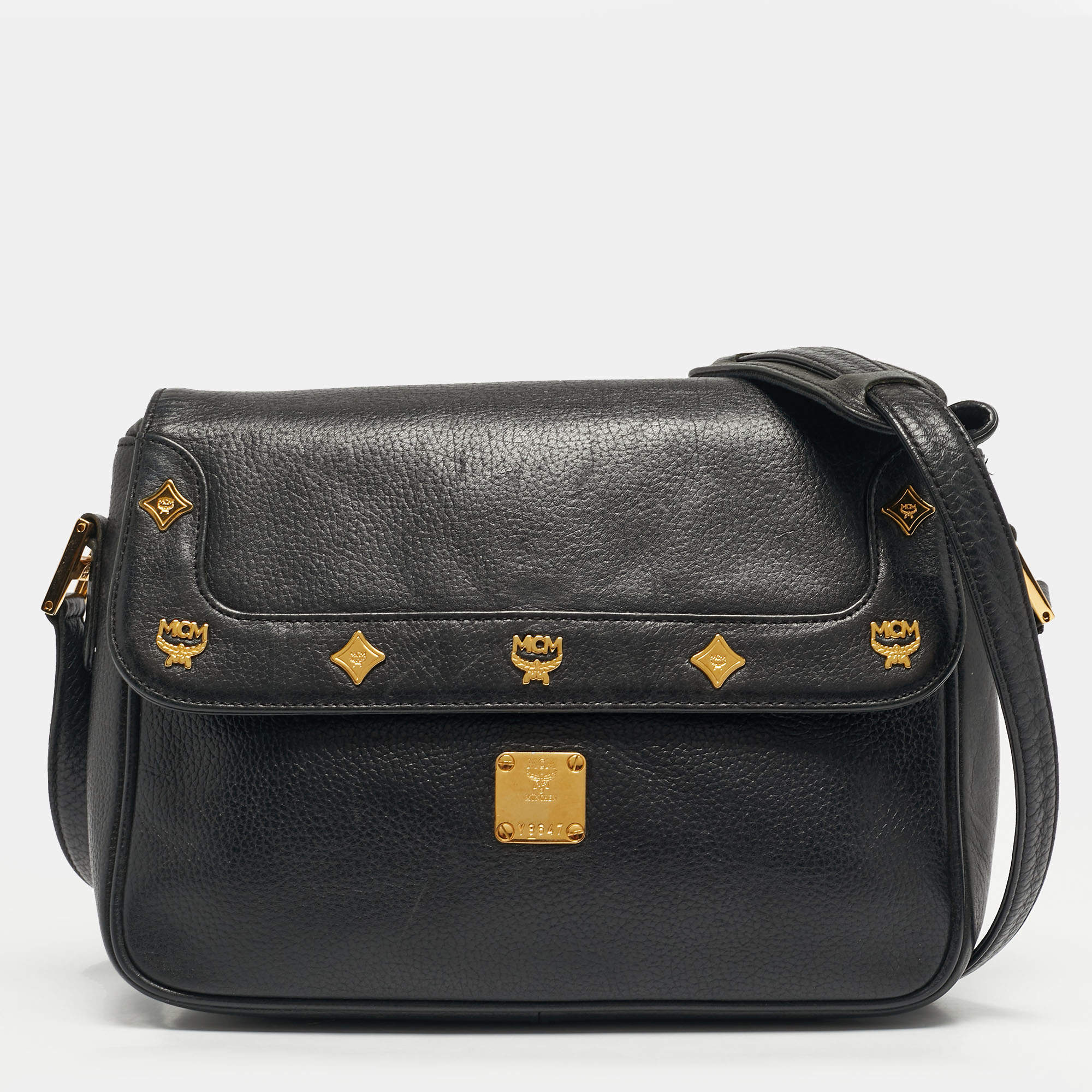 مملوكة مسبقًا حقيبة كتف بتصميم مغطاة بشعارات فضفاضة ومزينة بمسامير جلدية سوداء من أم سي أم