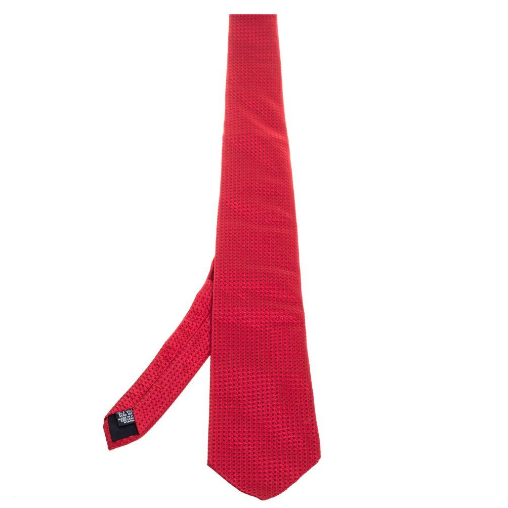 This fabulous tie from Boss by Hugo Boss is perfect for adding to your collection The red hued creation is made of 100% silk and features a checkered pattern all over. It comes with a penny keeper strap and the brand label neatly stitched at the back. It is sure to add oodles of style to your blazers.