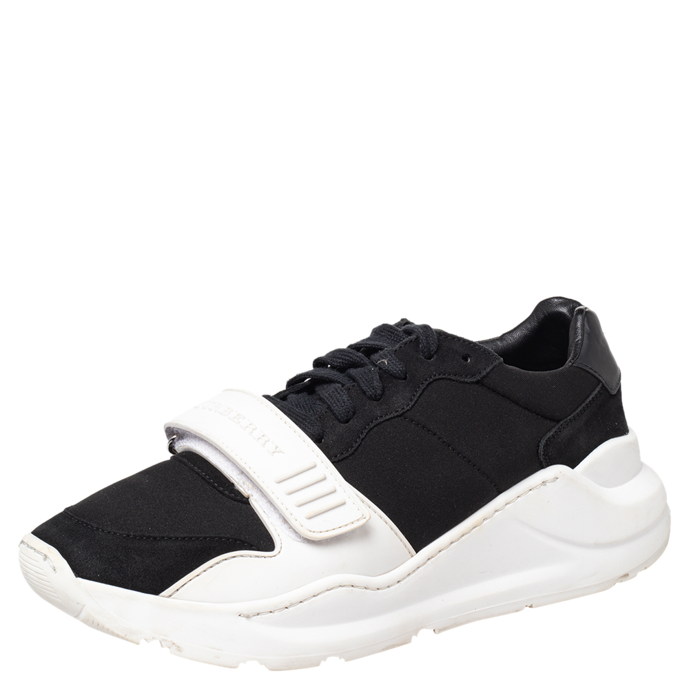 A sporty low top silhouette in leather neoprene and suede. Designed by Burberry the Ramsey sneakers have lace up closure and a velcro strap on the uppers. The design is mounted on chunky rubber soles.