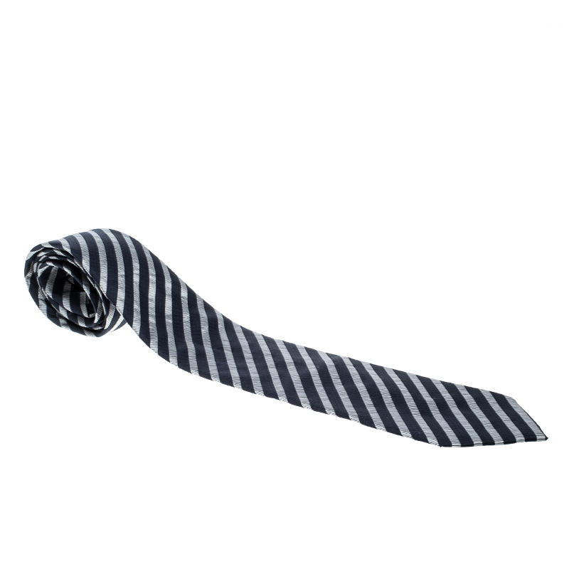 Luxuriously cut from silk this sophisticated tie comes from the house of Emporio Armani. The piece has stripes in navy blue and grey with the brand label as the keeper loop at the back. Team it up with formal attires for a sharp look.