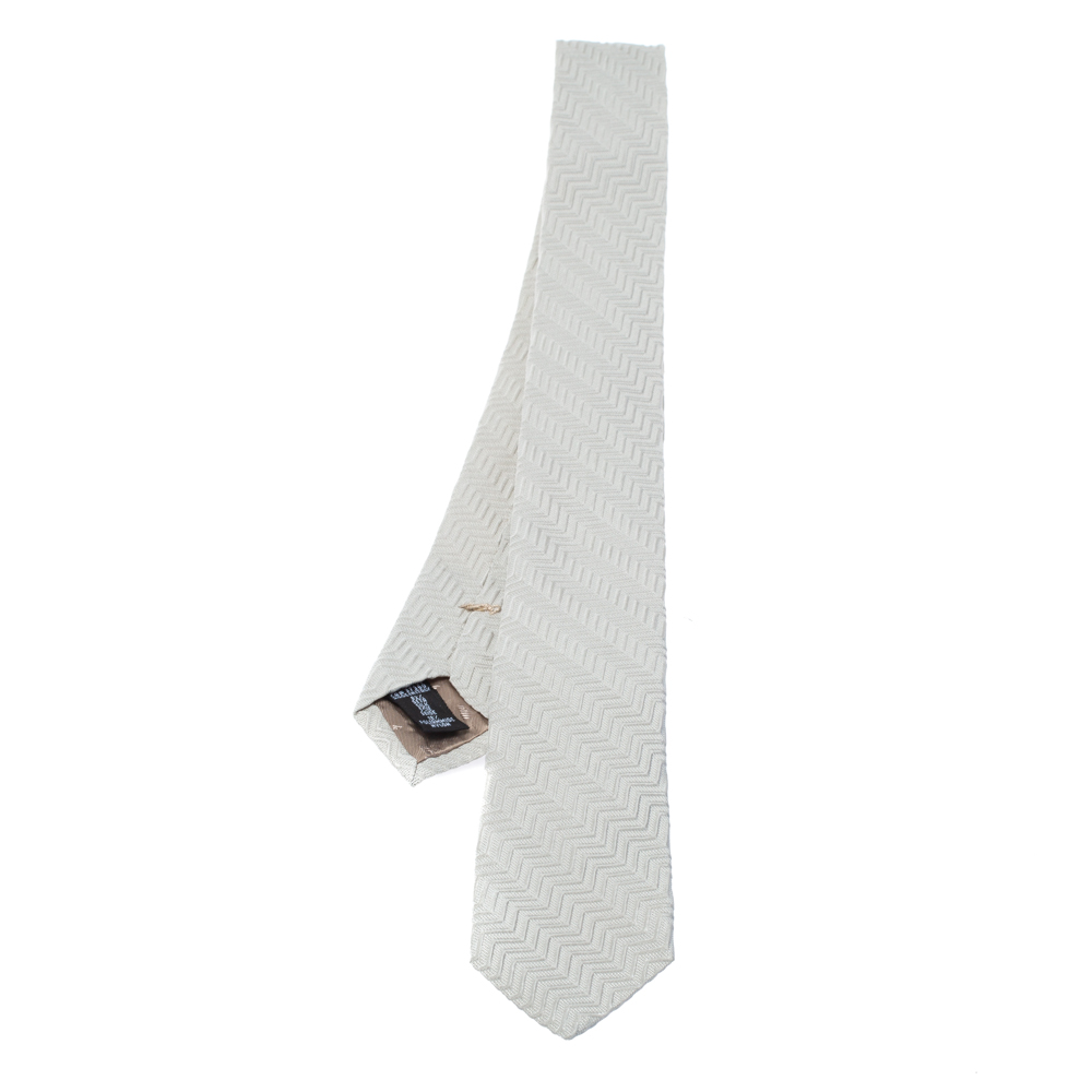 This suave silk tie from Emporio Armani is perfect for the chivalric you. Designed in an understated ivory shade this tie is designed with a zig zag pattern all over and comes with the brand label at the rear. Wear this to your most important meetings and you are sure to be the ideal gentleman.
