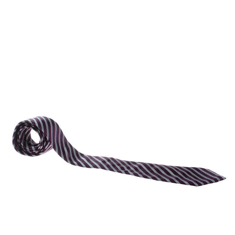 Cut from quality silk this Ermenegildo Zegna tie features purple and grey stripes all over. The piece is complete with a keeper loop on the back. Look smart by pairing it with crisp shirts.