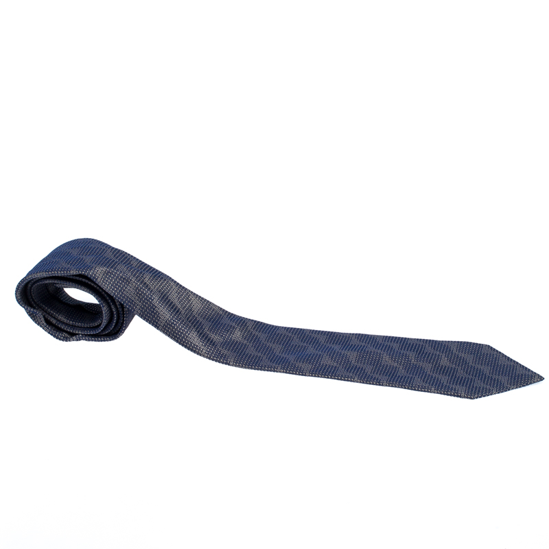 Cut from quality silk this Gianfranco Ferre tie in navy blue features patterns in jacquard all over. The piece is complete with the keeper loop at the back. Look smart by pairing it with plain shirts.