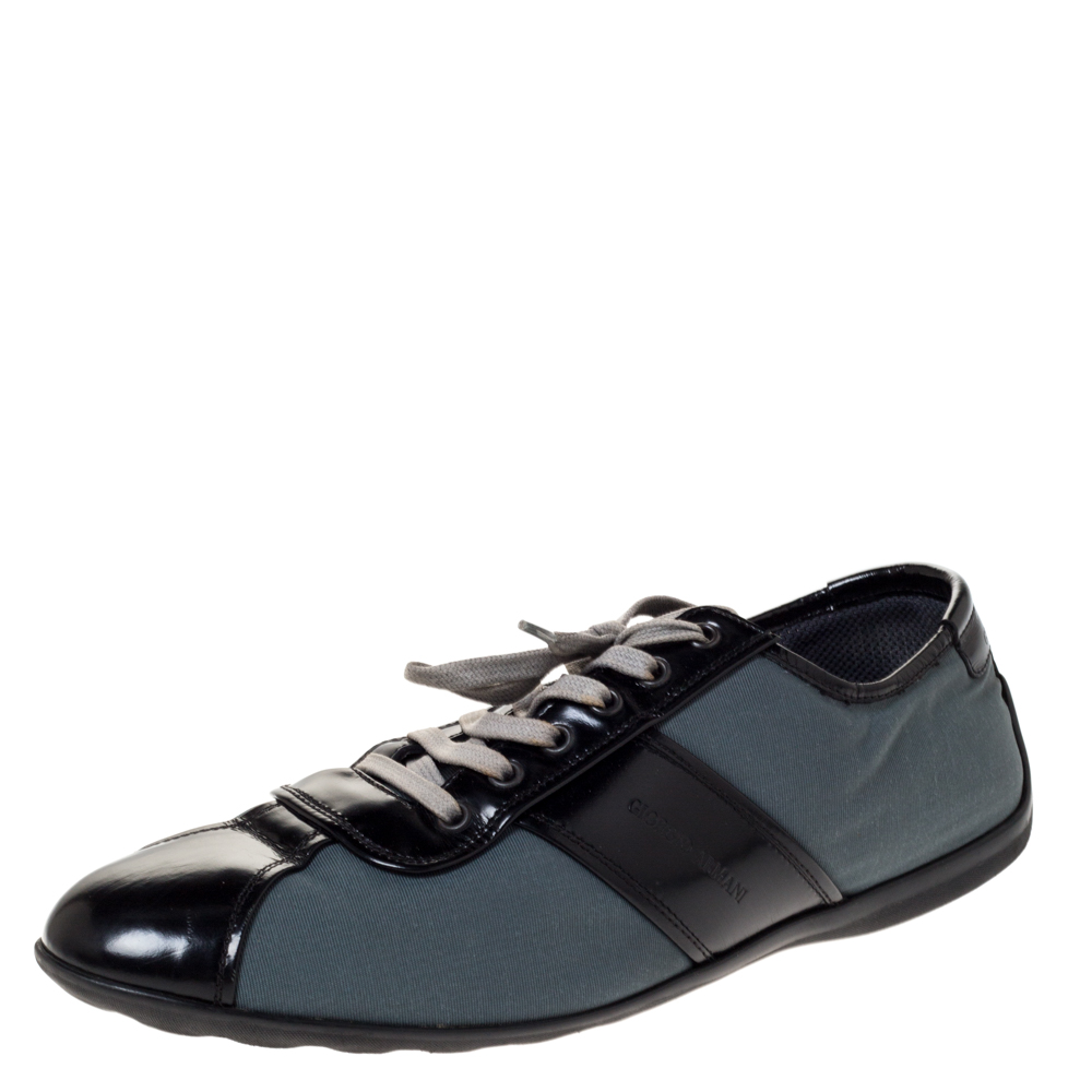 Giorgio Armanis low top sneakers are stylish and durable. Crafted from nylon and leather they come in lovely hues of black and dark teal. They are styled with round toes lace up vamps logo detailing on the sides and counters. They are finished with rubber soles.