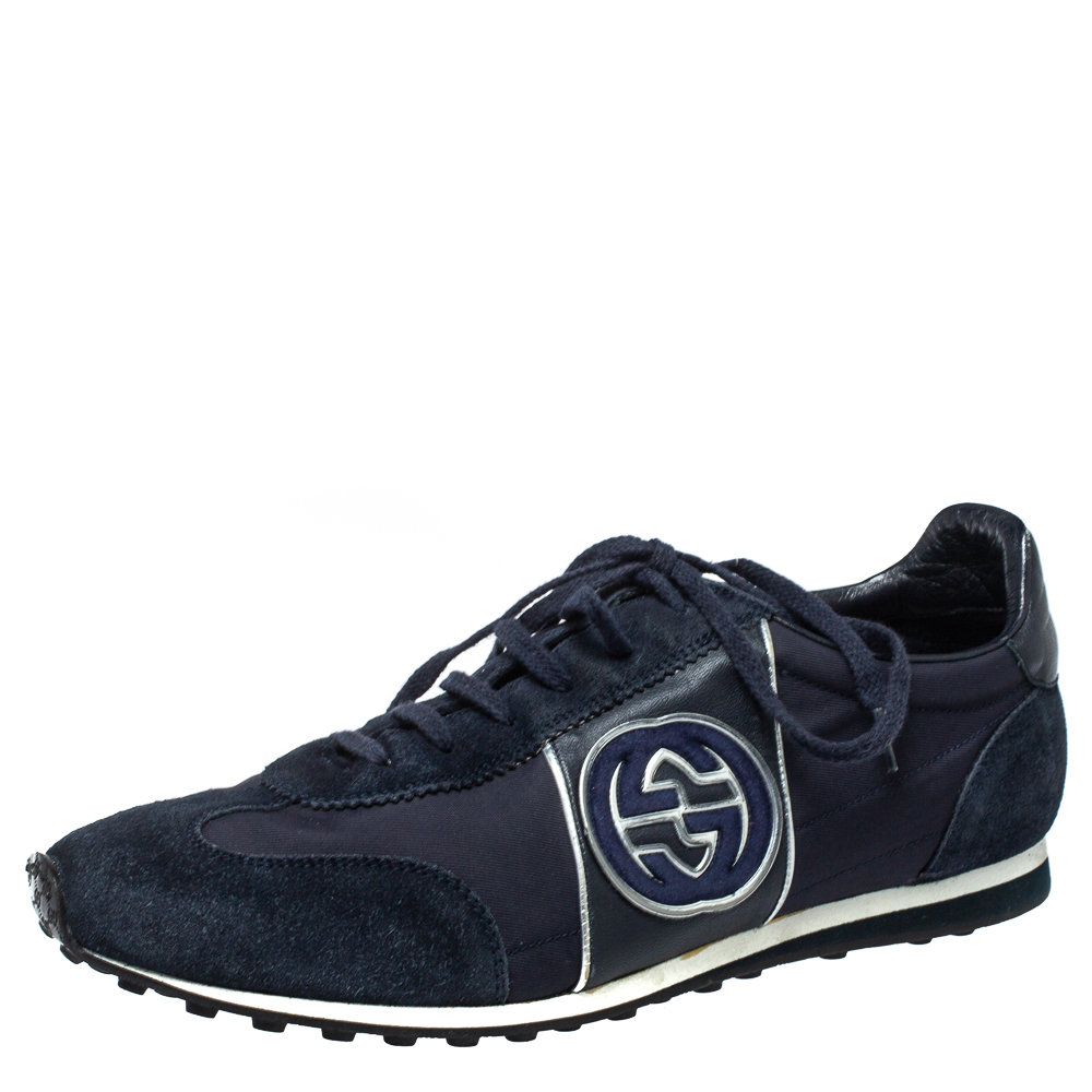 Enjoy footwear ease with this pair of sneakers by Gucci. Theyve been crafted from suede and fabric and designed with round toes lace ups on the vamps and the interlocking G logo on the sides. The leather insoles and rubber outsoles add to the comfort of this navy blue pair