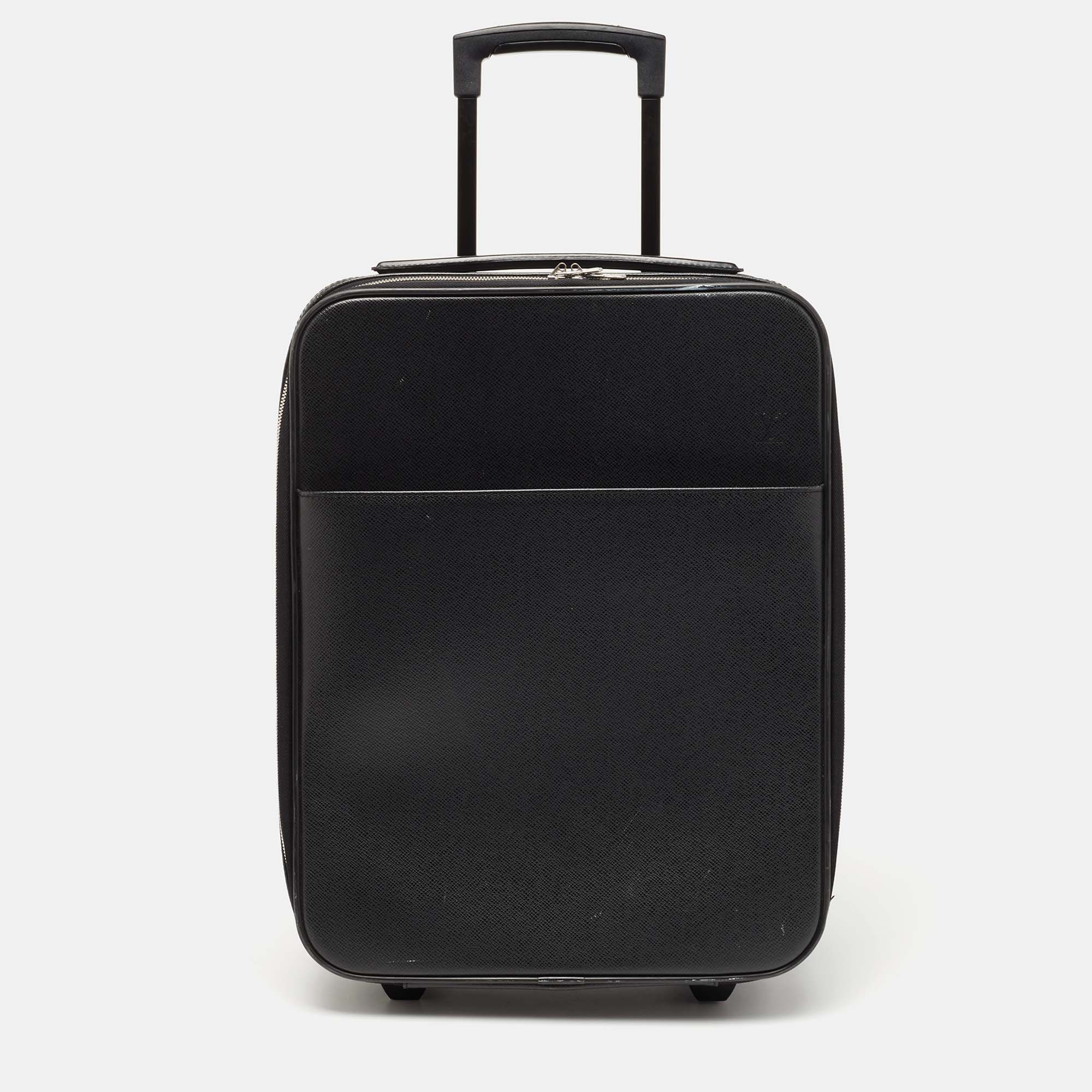 This Pegase 45 Business luggage from Louis Vuitton is super sturdy practical and stylish for long vacations. Crafted from Ardoise Taiga leather this luggage bag displays silver tone fittings a trolley handle and a neat nylon lined interior. For convenience this Louis Vuitton creation is the best buy