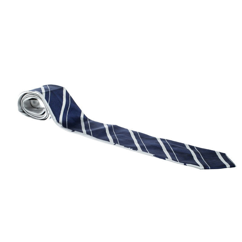 Pick this Prada tie to add a touch of grace to your corporate outfits. Made from silk the tie sports a deep blue hue decked with grey coloured stripes. The filling length and the supporting keeper loop makes this one an effortless piece of fashion to put on.