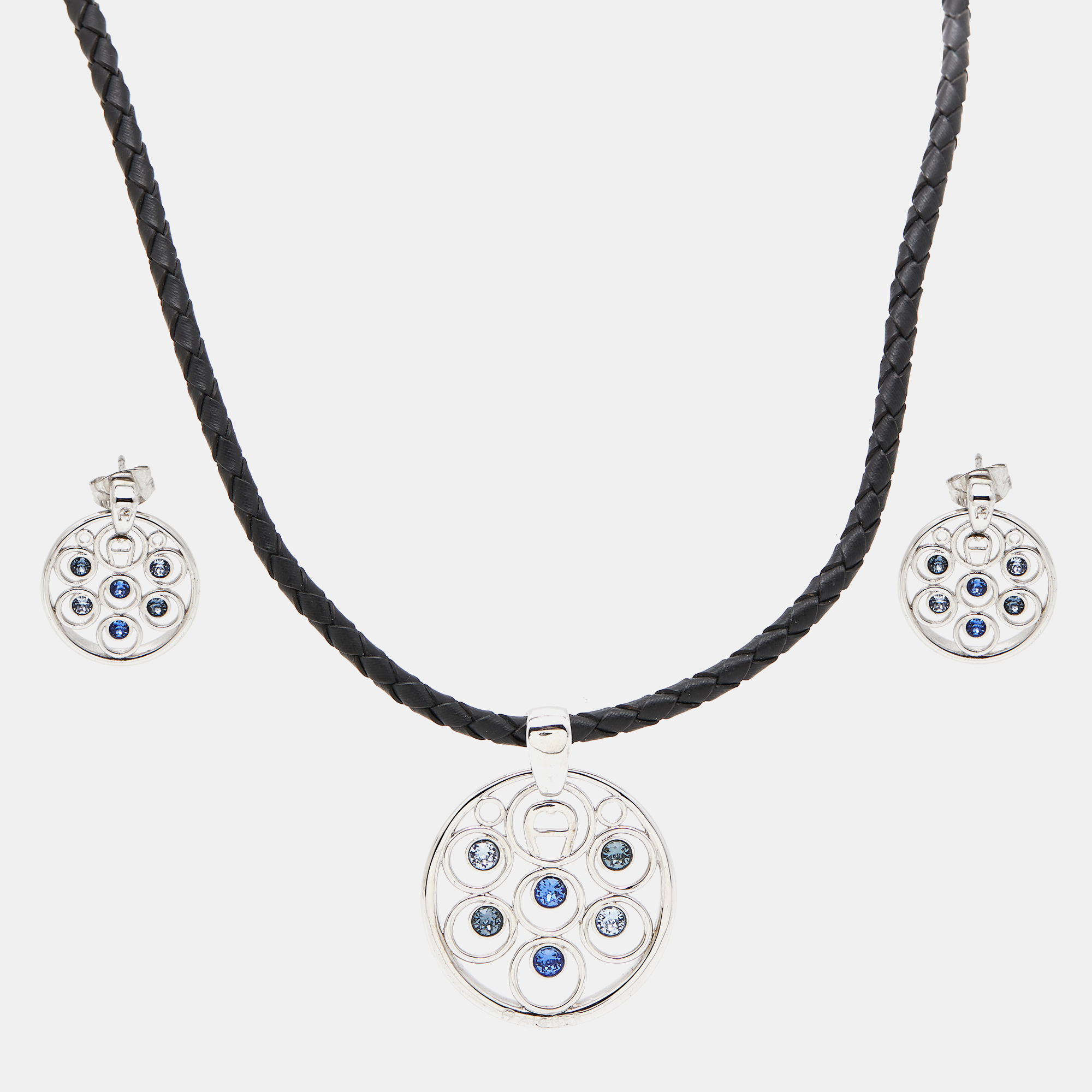 This delicate set from Aigner is made of silver tone metal and adorned with crystals. The necklace and earrings feature a lovely design added with the brand logo.