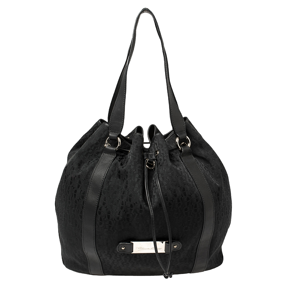 This lovely bag hails from the house of Aigner. It has been crafted from signature coated canvas and leather and carries a lovely shade of black. It has a drawstring closure top handles silver tone hardware and a spacious fabric lined interior. It is perfect for everyday use.