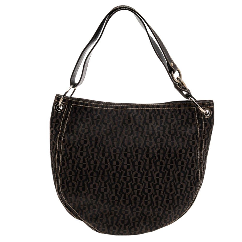 Include this hobo from Aigner in your collection to obtain a classy handbag design. This hobo is made using the signature nylon and leather adding a significant look to it. It is completed with a single adjustable handle and silver toned hardware.