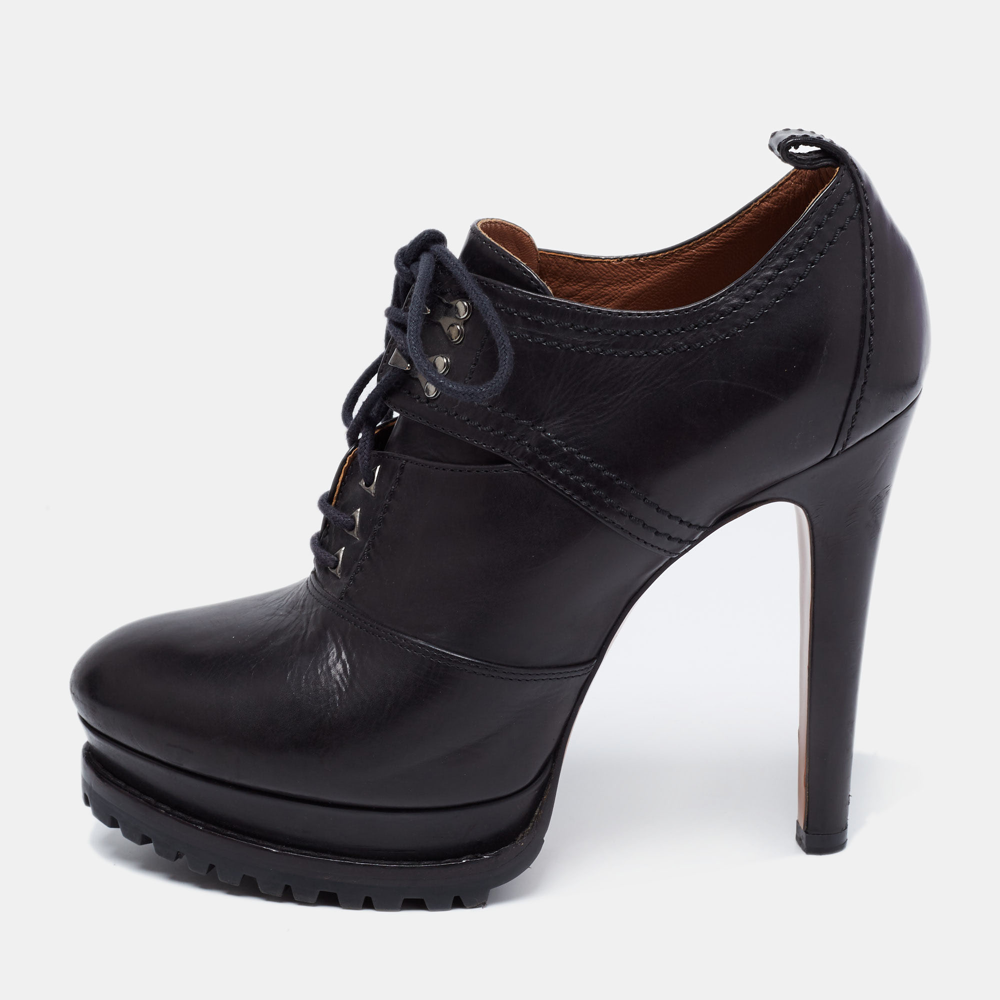 Crafted with perfection these Alaia booties will lend you a sophisticated style statement. The lace up vamps and a pull tab at the counter form the leather upper of this pair. Elevated on 13cm heels and platforms these shoes will take up your fashion sense to new heights.