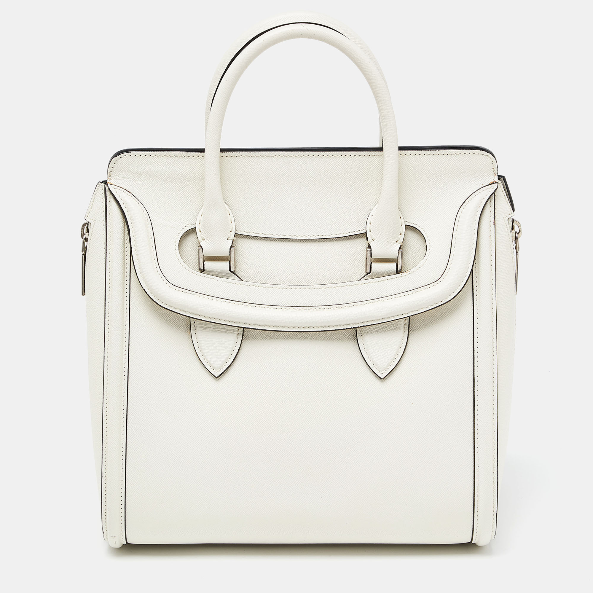 This classy bag from the house of Alexander Mc Queen is lovely Crafted in elegant off white leather this Heroine bag displays a structured silhouette. It features two rolled top leather handles and a unique slide cover flap. The interior is roomy and is lined with suede.