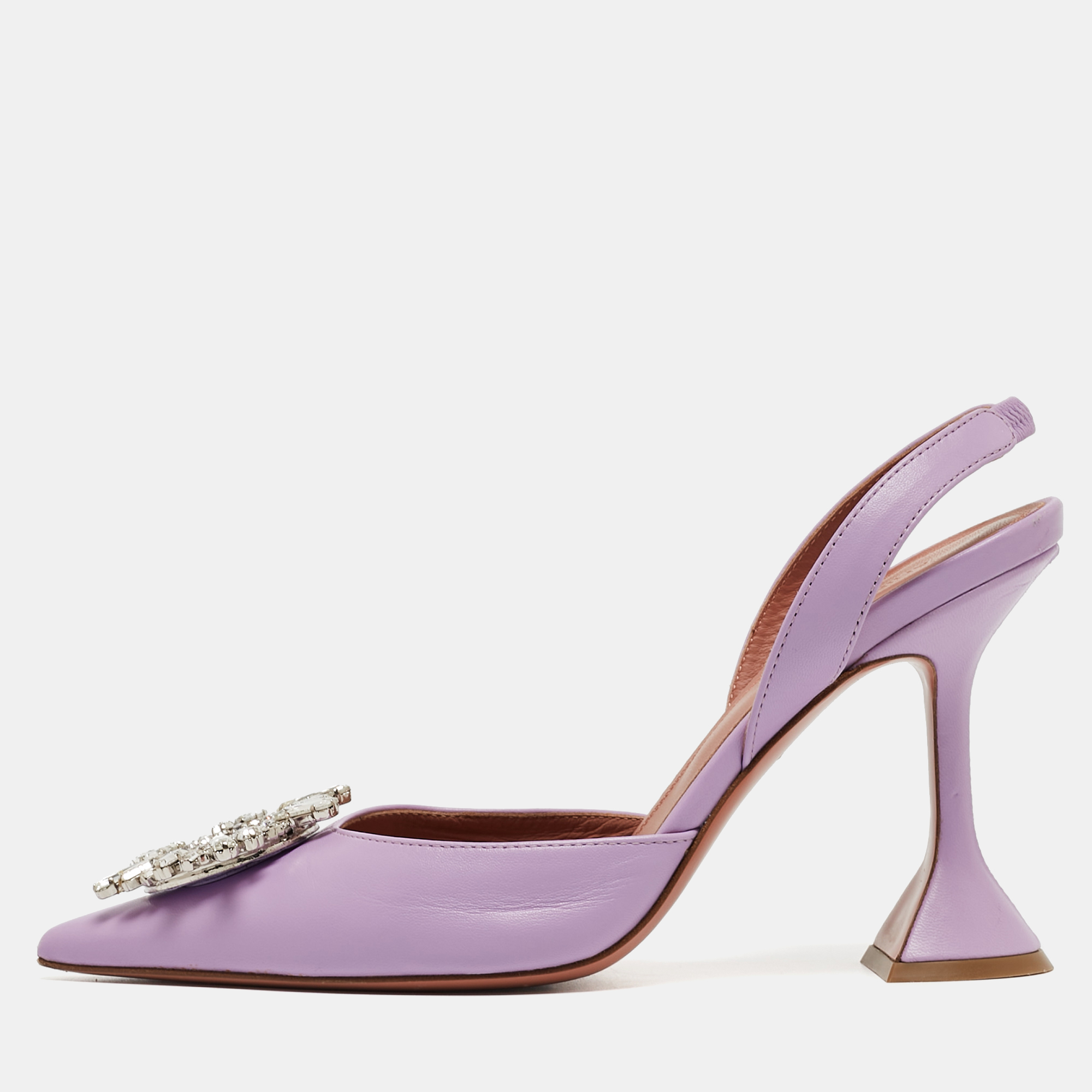 The Amina Muaddi Begum pumps are striking high heeled shoes. They feature transparent blue PVC uppers a pointed toe and a sculpted heel with a signature flared design. These pumps exude modern elegance combining transparency with a bold pop of purple for a unique and stylish look.