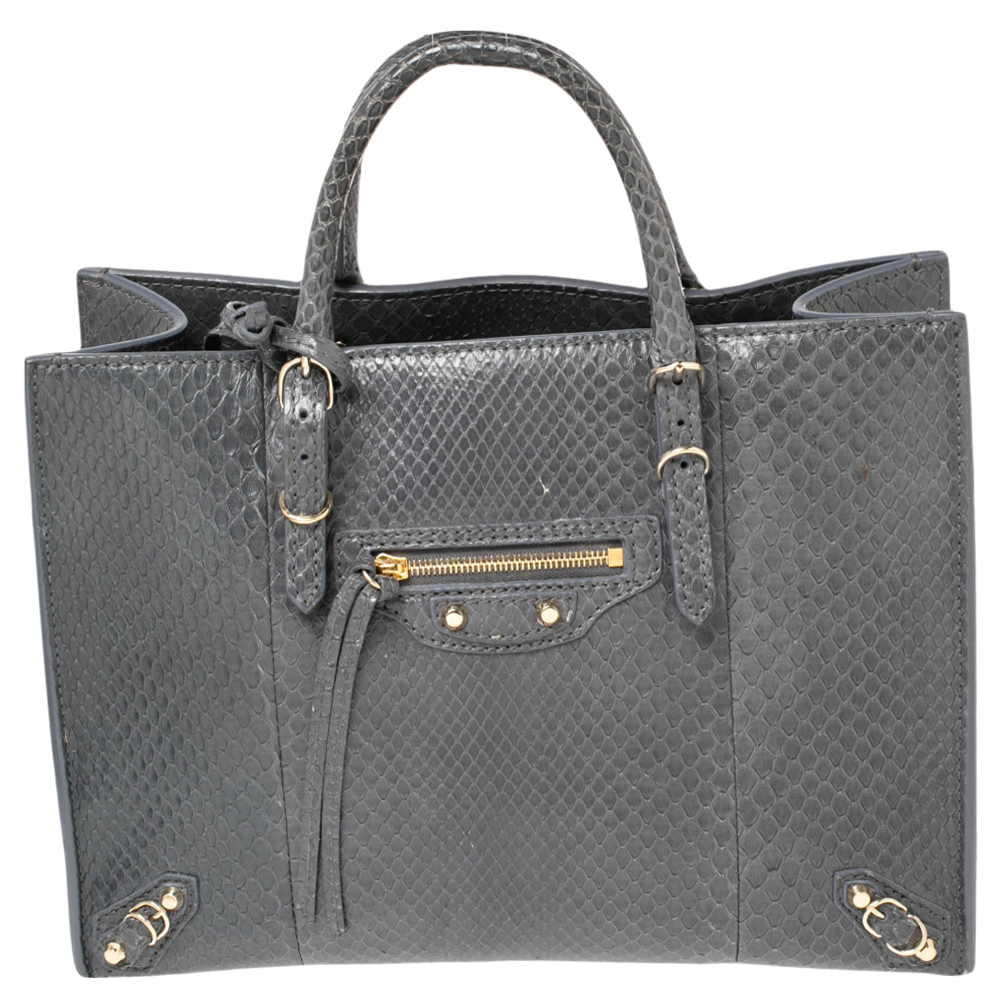 This Papier A6 bag from Balenciaga smoothly blends luxury with practical fashion. It comes crafted from python leather and styled with two top handles a leather interior and a detachable strap. The front is detailed with a signature zipper and buckle accents.