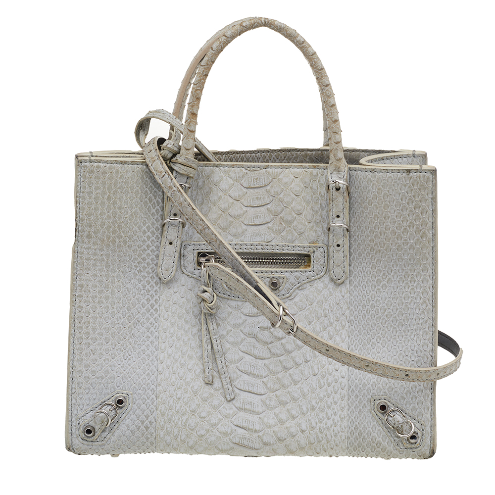 This Papier A6 bag from Balenciaga smoothly blends luxury with practical fashion. It comes crafted from python leather and styled with two top handles a suede interior and a detachable strap. The front is detailed with a signature zipper and buckle accents.