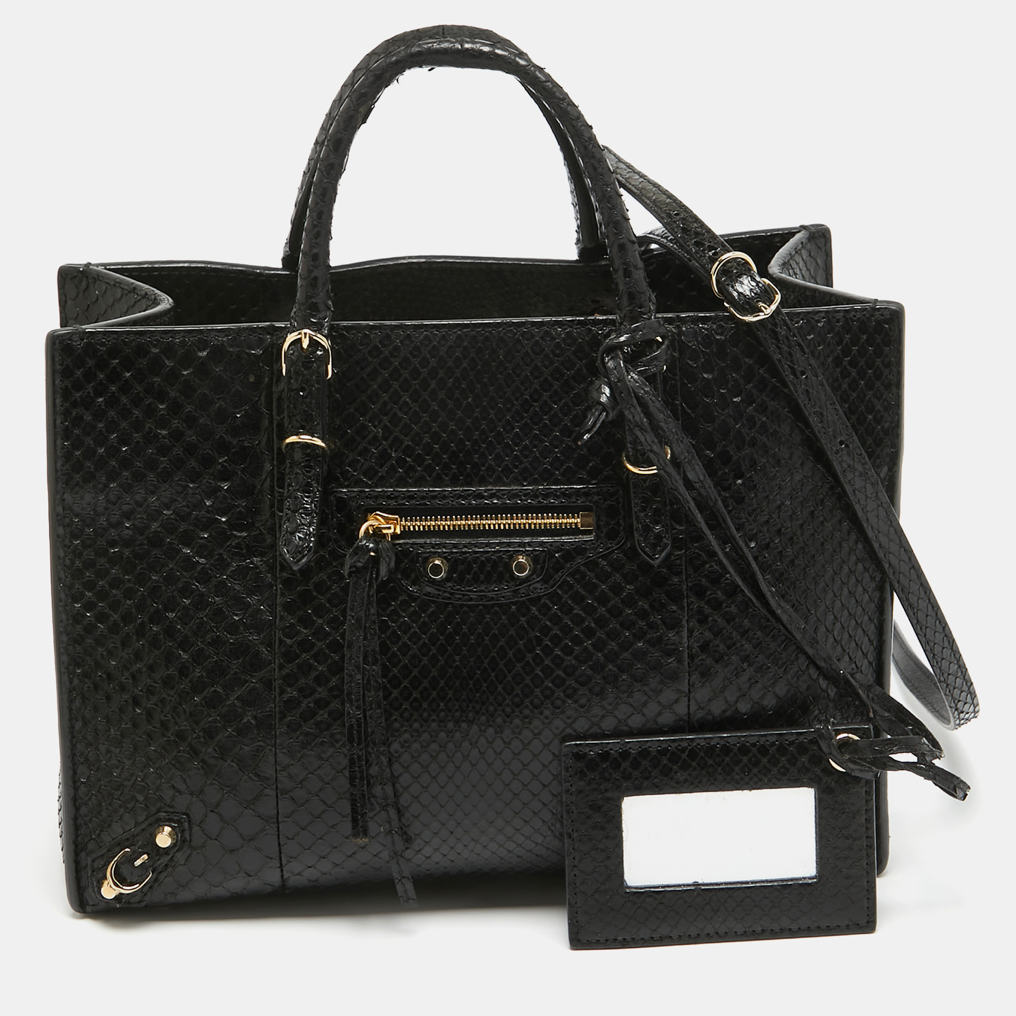 The Papier A6 bag from Balenciaga smoothly blends luxury with practical fashion. It comes crafted from python leather and styled with two top handles a leather interior and a pocket mirror. The zippers and buckle detailing make the bag such a worthy catch