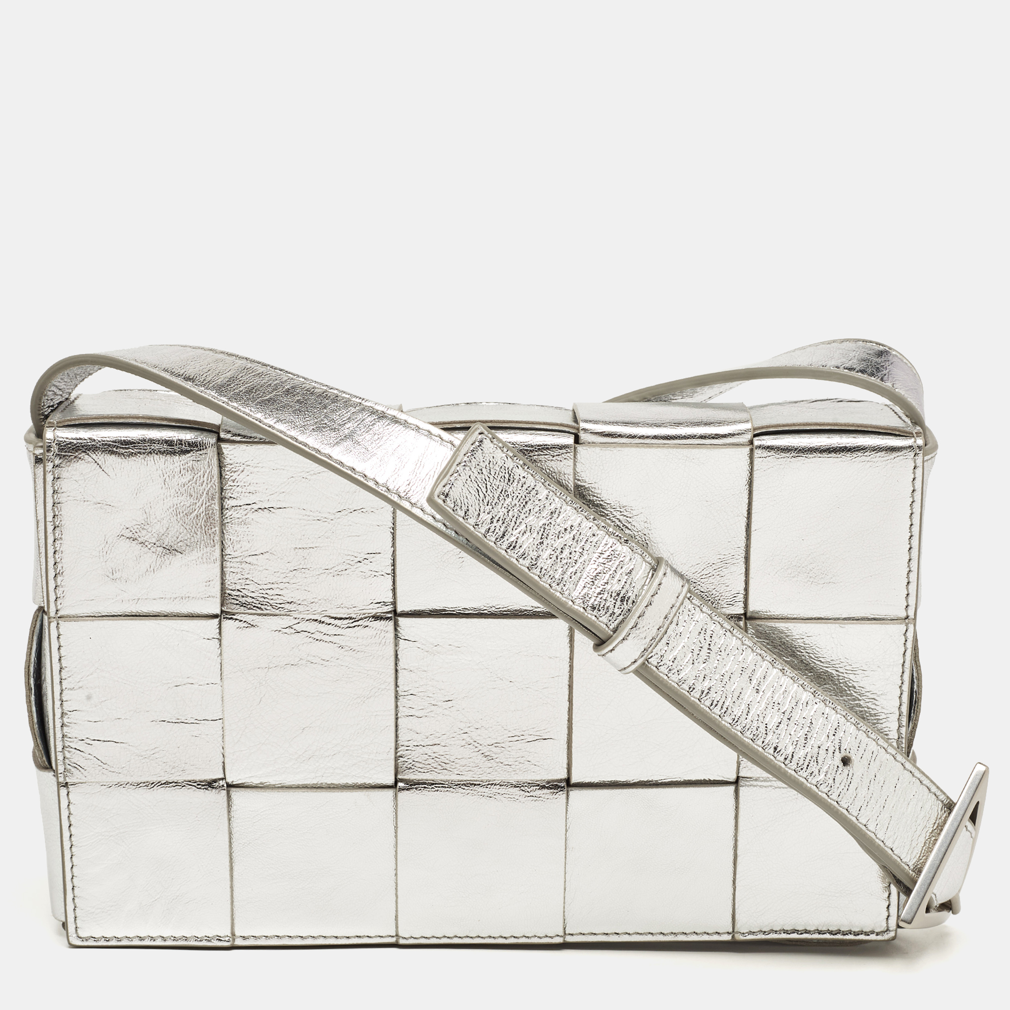 The Cassette bag by Bottega Veneta is all things stylish trendy and instagrammable. With its playful take on the brands signature house code the Intrecciato weave the bags exterior flaunts a maxi version of the weave. It is crafted from quality leather in a lovely shade of silver. The front flap opens gracefully to an interior sized perfectly to carry your essentials.