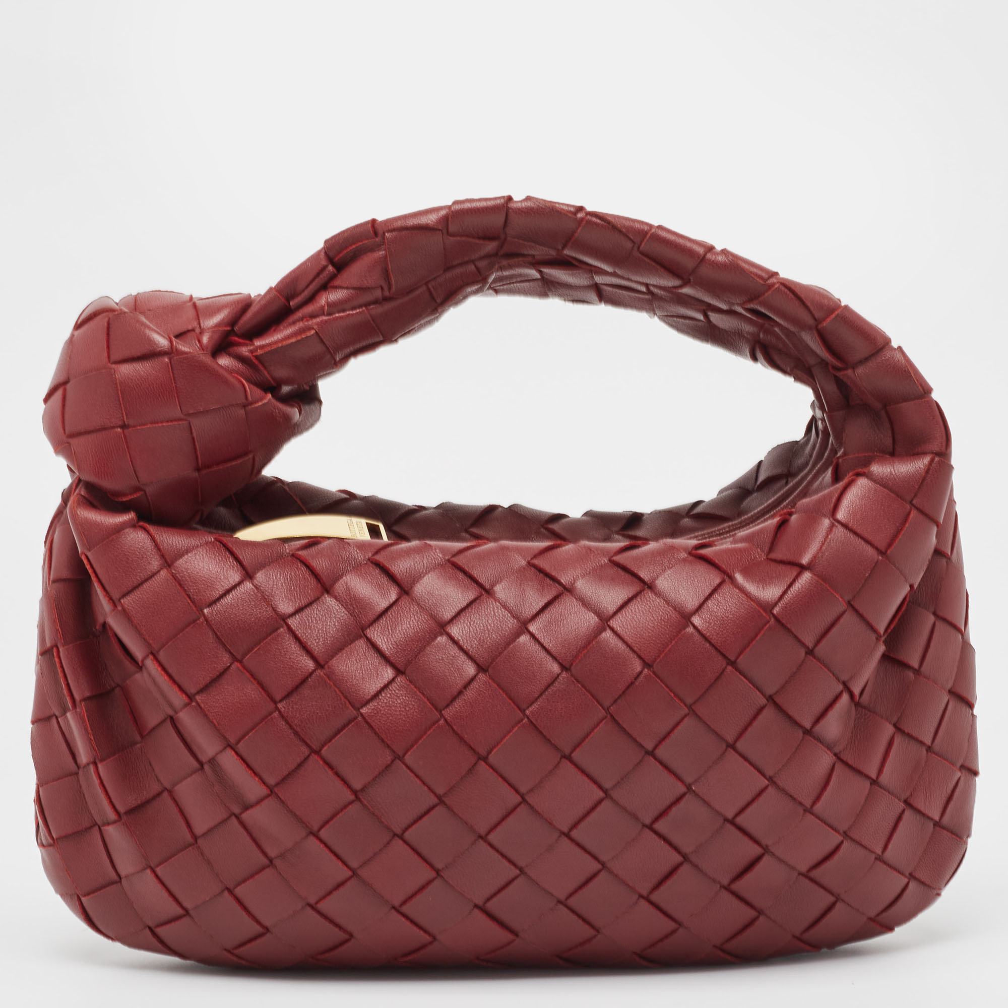 This Bottega Veneta Jodie bag is crafted from leather using their signature Intrecciato weaving technique into a seamless silhouette. This mini bag personifying elegance and subtle charm is held by a knotted handle. The bag has an interior sized to hold your days essentials.