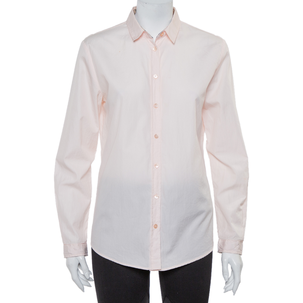 Easy to pair with both pants and skirts this Burberry Brit pink shirt for women is tailored using cotton into a smart design. It features a simple collar with Nova Check trim inside front button fastening and full sleeves.