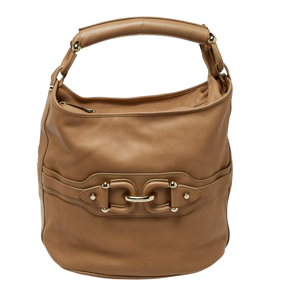 Burberrys equestrian sensibilities come alive in this hobo that is practical and stylish. Crafted from leather in a beige shade it features a horsebit motif a spacious interior and a single handle. This bag can be carried for every day use.