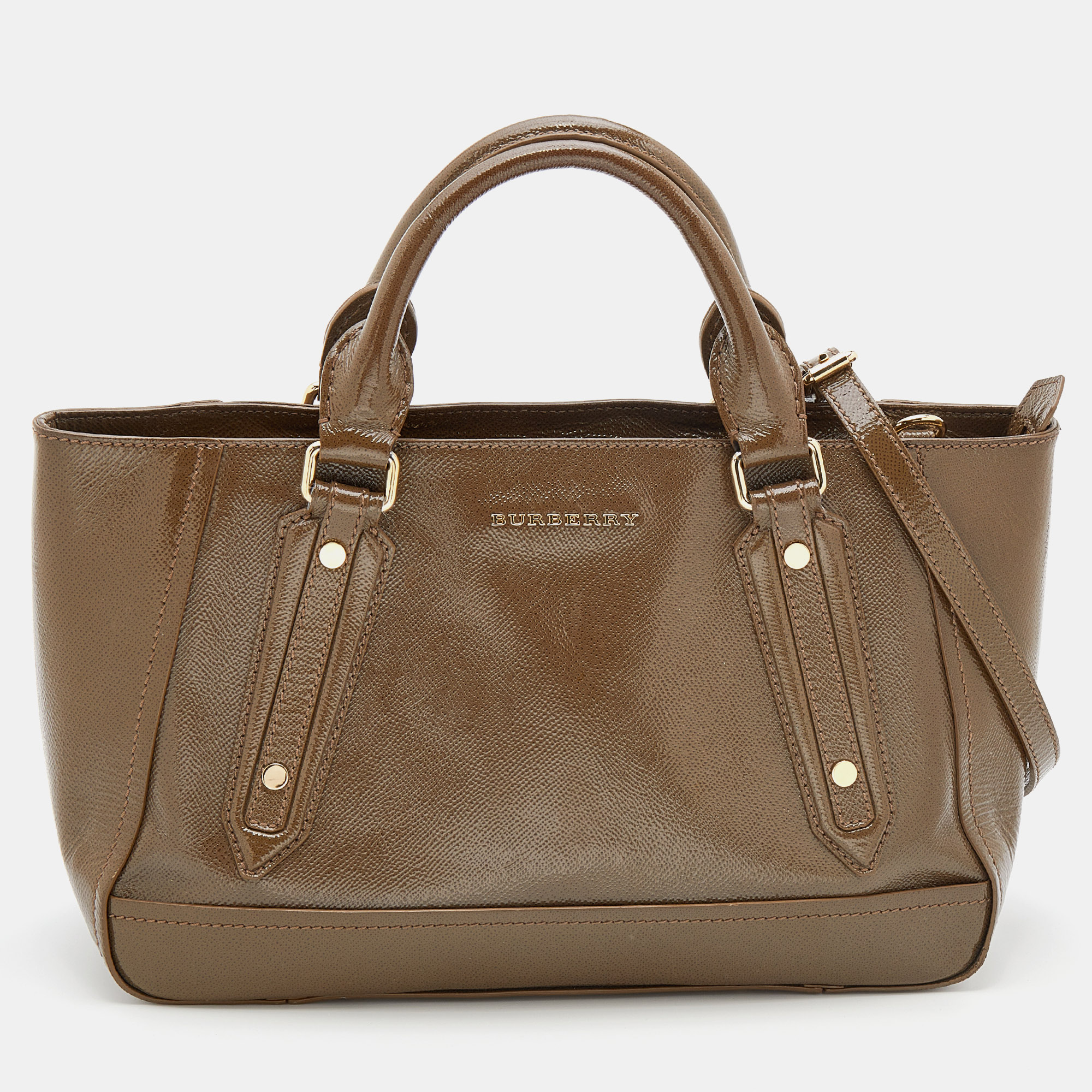 Burberry brings us this classy tote that has been crafted from patent leather. It has a brown hue a spacious fabric interior capable of carrying your essentials with ease and a brand signature on the front. The piece comes equipped with protective metal feet two top handles and a detachable shoulder strap.