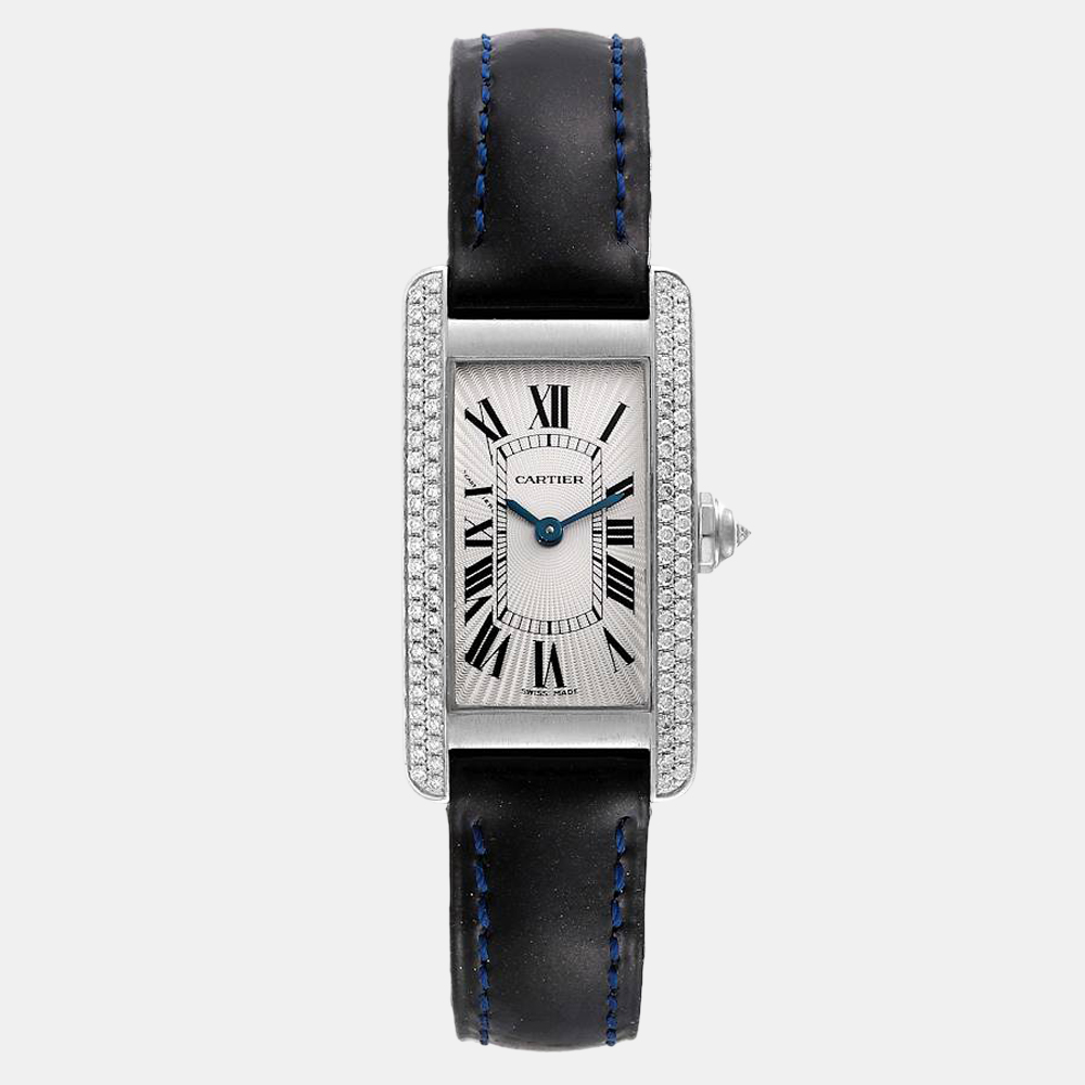 Cartier presents this sophisticated wrist watch that has a tank 18k white gold case and a matching bezel set with diamonds. It encases a silver guilloche dial which features painted black Roman numerals as hour markers and blue steel sword hands. The watch is secured by a black leather strap.
