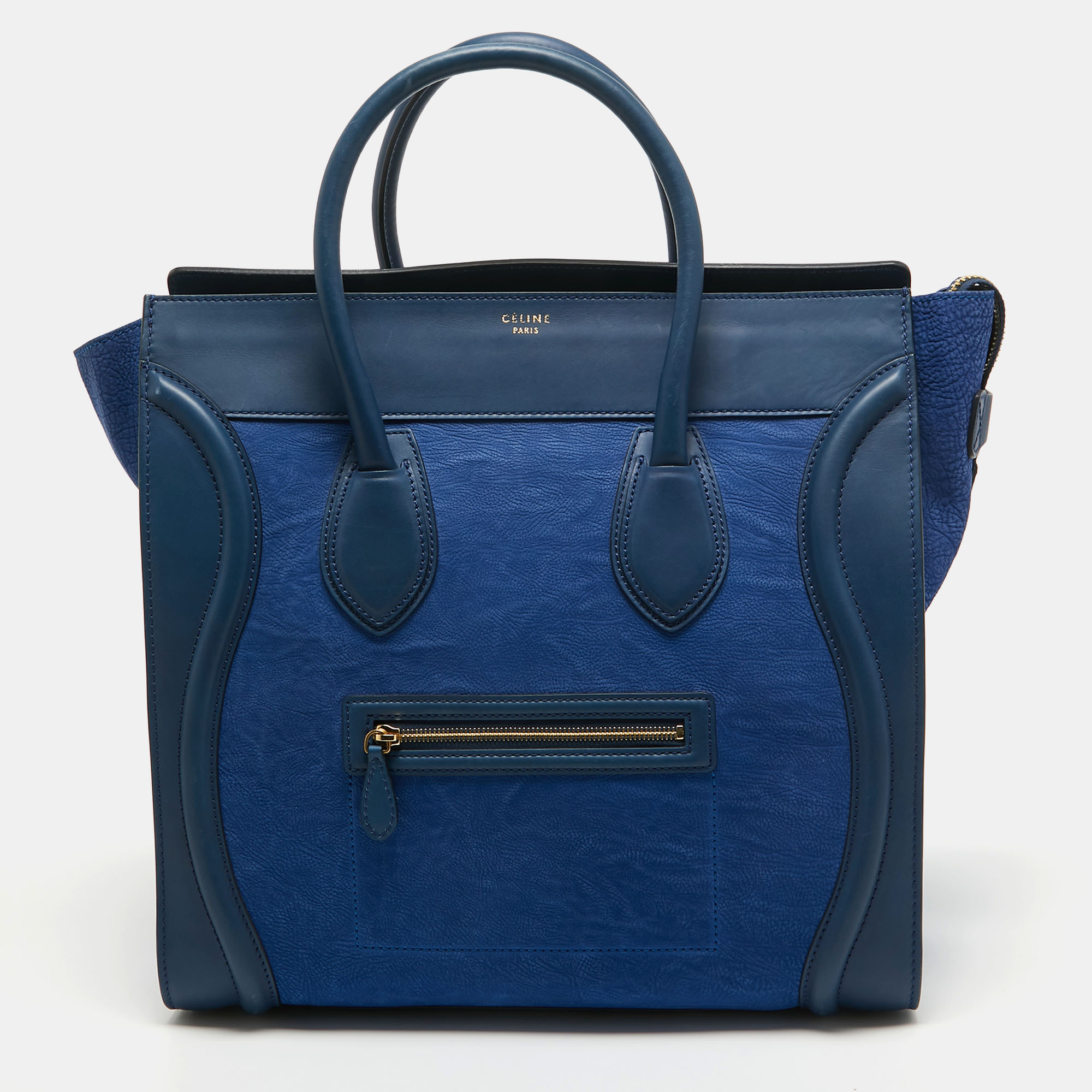 The usage of two tone blue leather on the exterior gives this Celine tote a high appeal. An eye catching accessory the bag features a front zipper pocket dual handles at the top and gold tone hardware. The leather lined interior is equipped to store more than just your phone and tiny essentials. The flappy wings at the sides and the brand signature on the front complete this design.