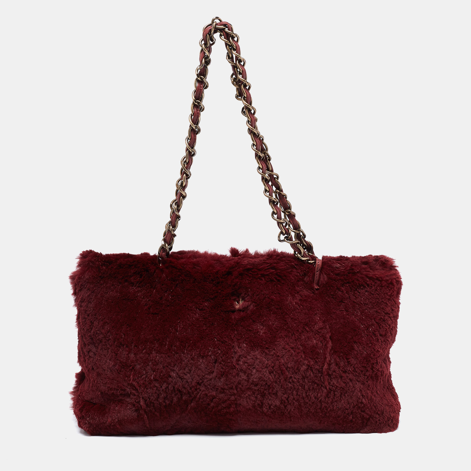 Add a winning touch to your attire with this stylish Chanel shoulder bag. It carries the same elegance and beauty as the labels other iconic bags; however its eccentricity lies in its unique construction. Crafted from burgundy colored fur it features a smooth exterior. Its interwoven shoulders straps allow you to tote the bag on your shoulders. The bag opens to a leather interior with enough space for your essentials and a zip pocket. This is the perfect accessory to complement your statement looks.