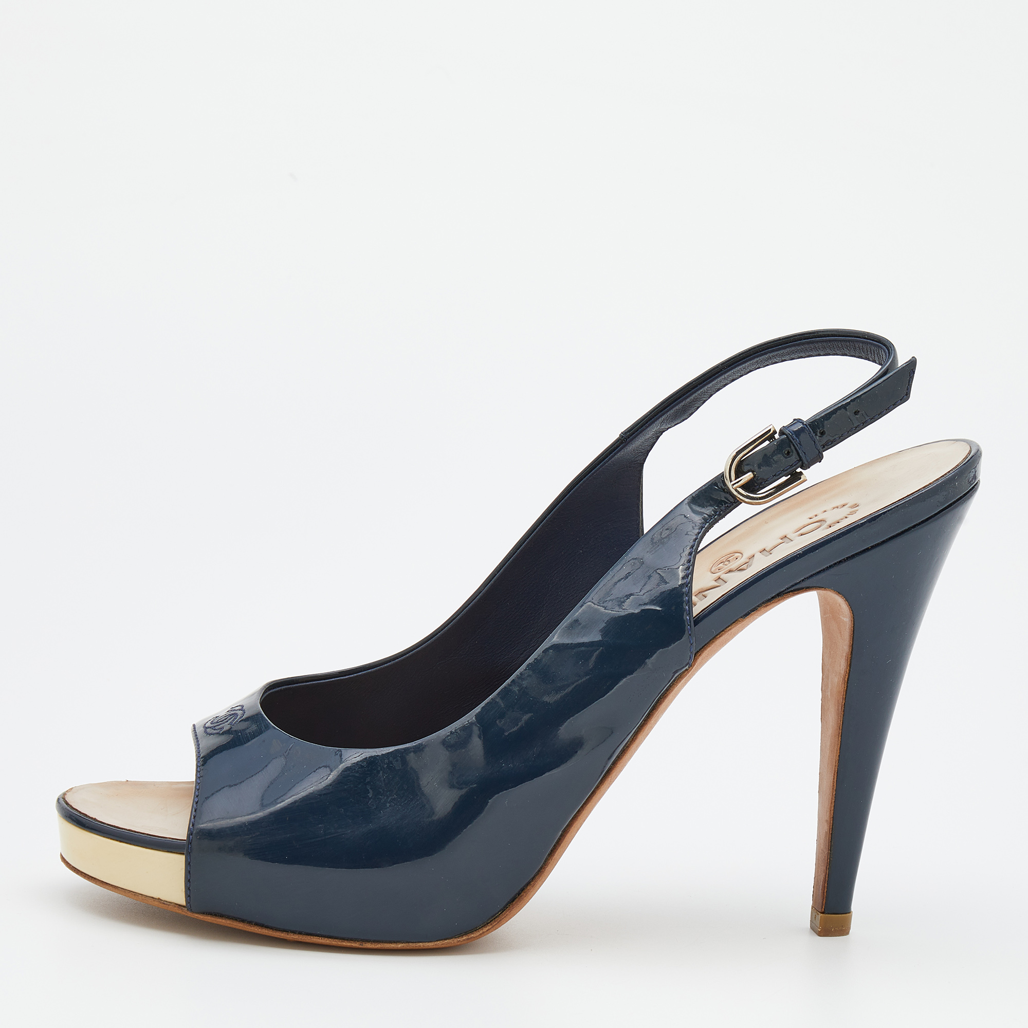 Offering comfort with elegance these Chanel slingback buckled sandals are a wardrobe essential. Crafted in navy blue patent leather the open toe features a platform. The pumps have insole lining that profiles the brands signature and are complete with high heels.