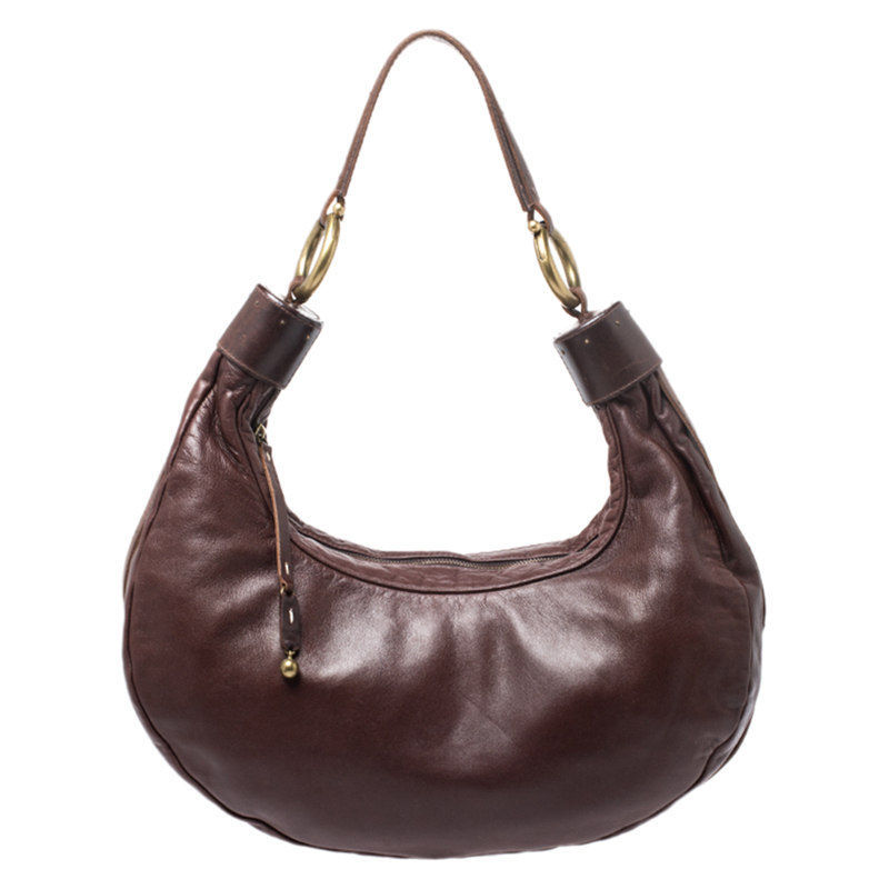 This Chloe design has a dark brown leather exterior and gold tone hardware. The hobo carries a crescent shape and features a top zip closure that opens to a fabric lined interior with the brands label. Raise your style quotient by flaunting it with work suits and even casual dresses.