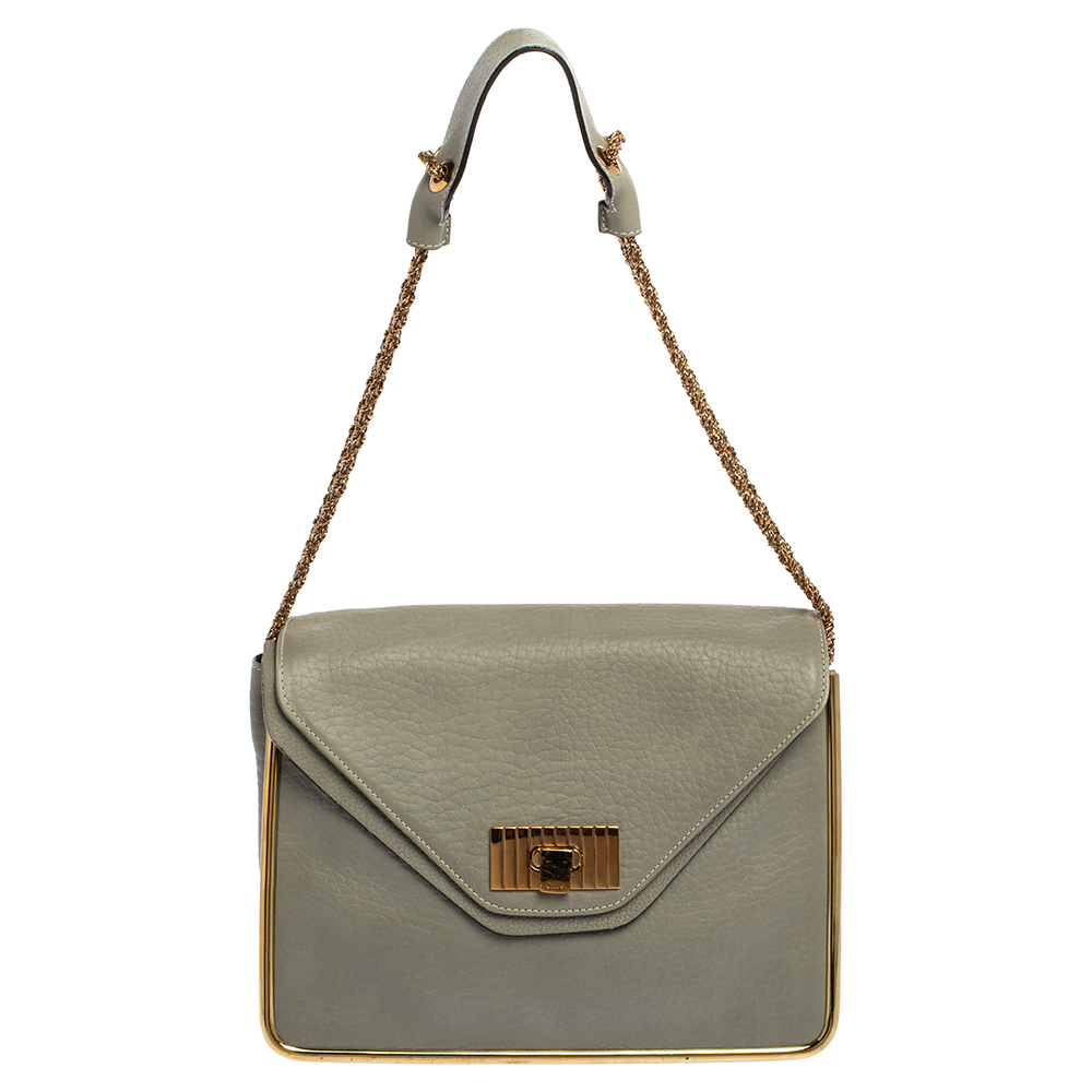 This stylish Sally shoulder bag from Chole is crafted from grey hued leather. The bag features a chain link strap with leather shoulder rest and a stunning flip lock in gold tone. The flap opens to a spacious fabric lined interior that houses a zip pocket to keep your essentials safe. Make all eyes turn towards you when you step out in style with this beautifully crafted bag