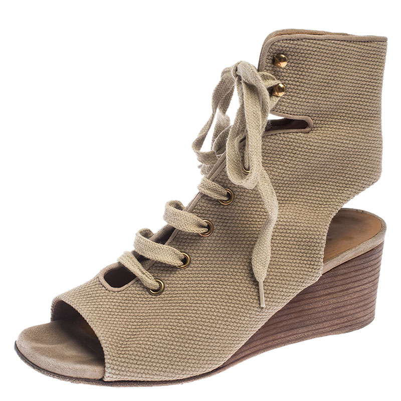 A perfect mix of elegant fashion and comfortable style these Chloe sandals come crafted from canvas and detailed with lace ups and open counters. Theyre visually stunning and they stand tall on wedge heels.