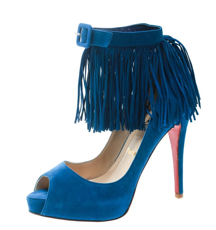 Youre all set to rock that fashionable outing in these stunning Tina pumps from Christian Louboutin Crafted from suede in a lovely cobalt blue shade these pumps feature a peep toe silhouette and flaunt fringe detailed buckled ankle straps that look amazing. They come equipped with comfortable leather lined insoles 12 cm heels concealed platforms and the signature red lacquered soles. Pair them with a knee length dress and an embellished sling bag.