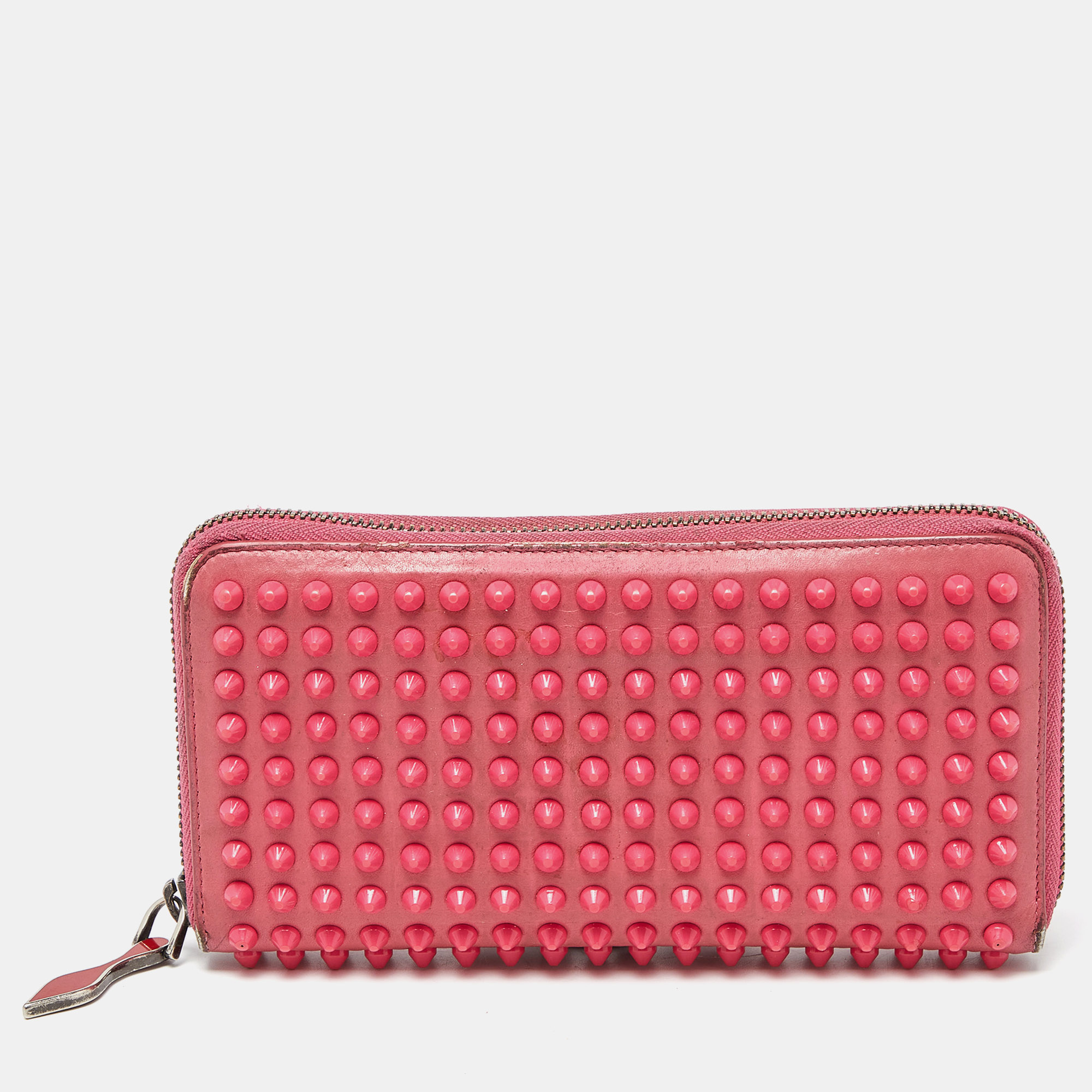 When youre not admiring the beauty of Louboutin heels youve got to get your hands on this stunner of a wallet that is anything but ordinary This pink wallet is crafted from leather and features spikes adorning the exterior. It flaunts a zip around closure that opens to a leather and fabric interior housing a zip pocket open compartments and multiple card slots. It can be carried in hand or else stacked inside a bag.