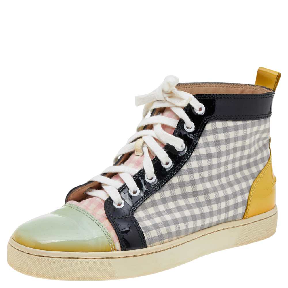 Christian Louboutin adds a statement look to these sneakers. They are crafted from a mix of patent leather and tartan fabric and secured with laces. The red soles of these high top Louis sneakers will highlight every step you take.