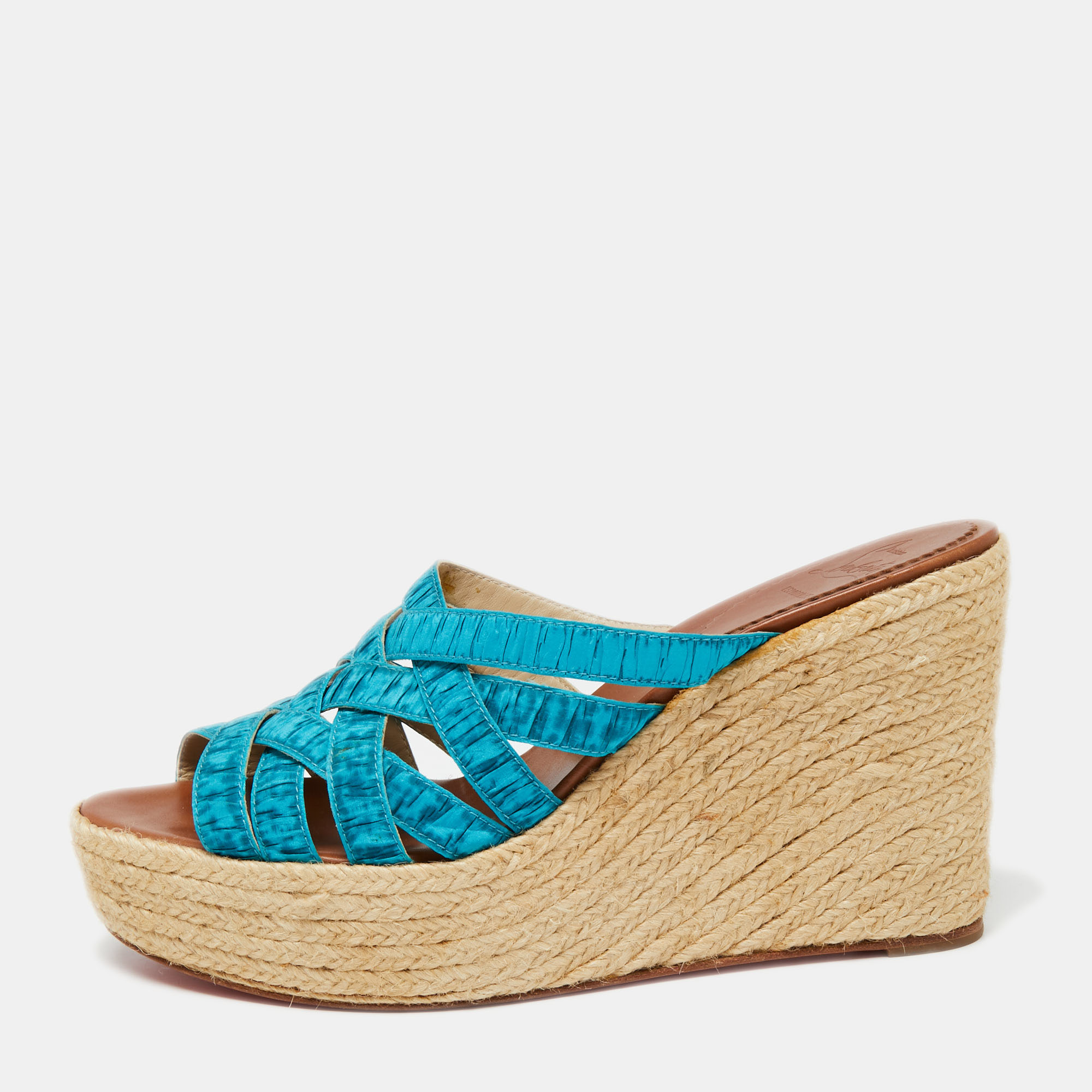 Christian Louboutin brings a perfect pair for the summer season These sandals come with a blue strappy upper that will frame your feet in the most elegant way. The espadrille wedge heels are supported by platforms for the comfort of your feet.
