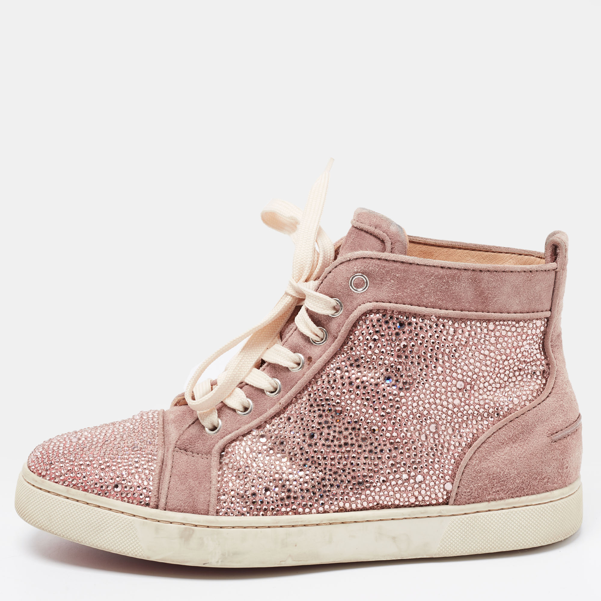 To bless your feet with comfort and style Christian Louboutin brings you these beautiful high top sneakers. The pretty pink embellished sneakers are made from suede with leather insoles. The tongue pads lace ups and durable rubber soles complete the snug yet chic look.
