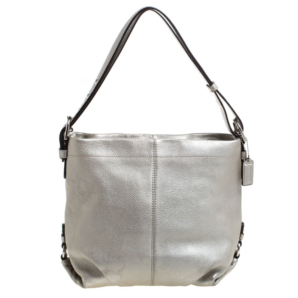 An absolute delight to carry on any day this hobo is a Coach creation. Crafted from leather the bag features a metallic silver shade a single handle and an interior sized perfectly to hold your essentials. This bag is a must have.