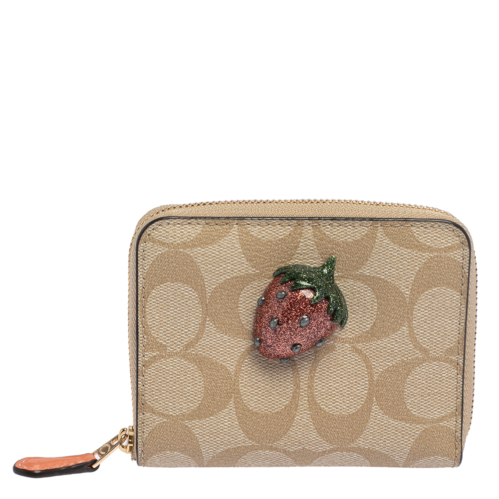 Stylish wallets are a closet must have Crafted from signature canvas this beige wallet is a Coach creation. The wallet is lined with nylon on the insides and flaunts a pretty strawberry applique at the front.