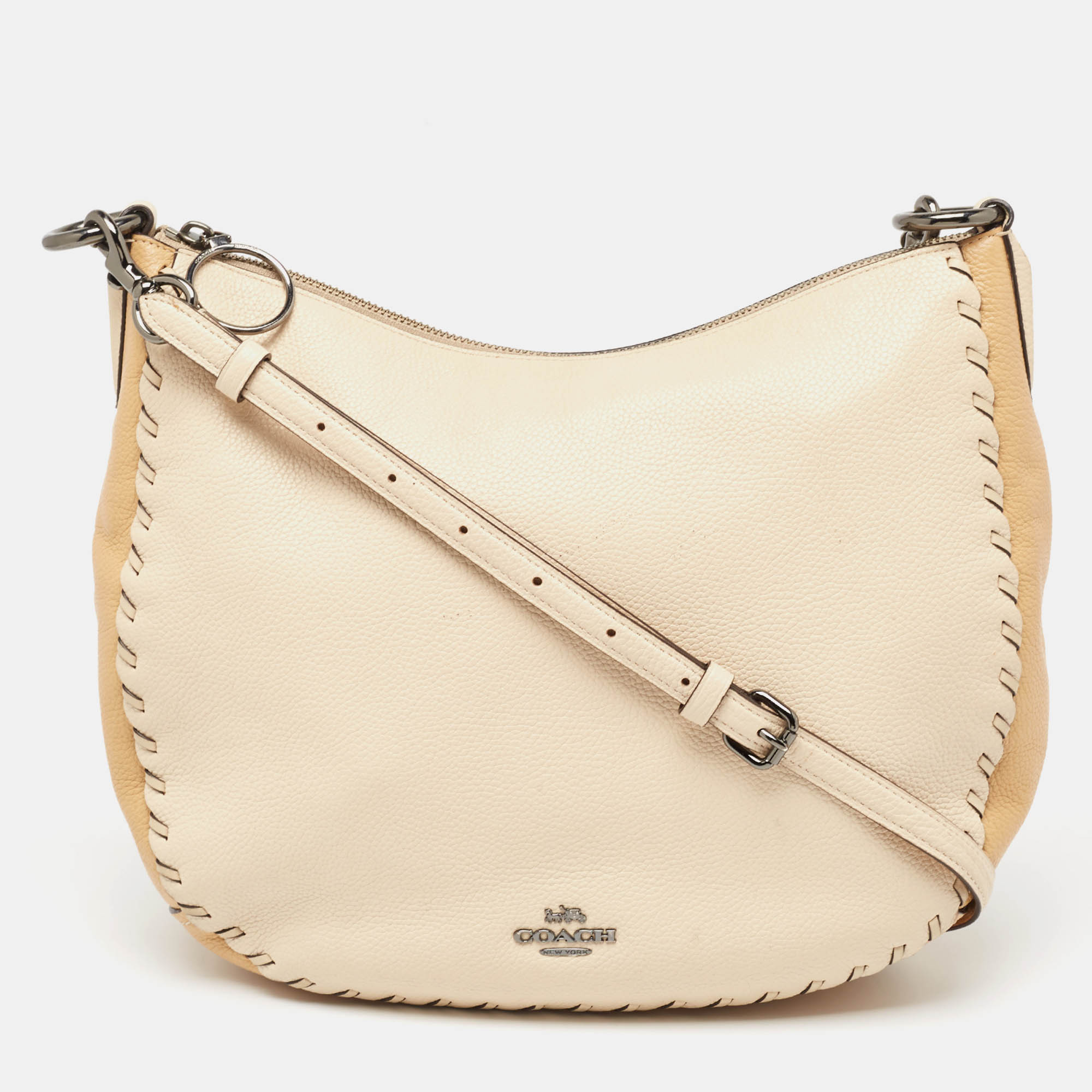 Visually alluring and finely crafted is this Sutton hobo made from beige leather. The bag has the brand detailing in gunmetal tone on the front and a lined interior to safely hold your essentials. A great everyday option this Coach bag is surely a must have