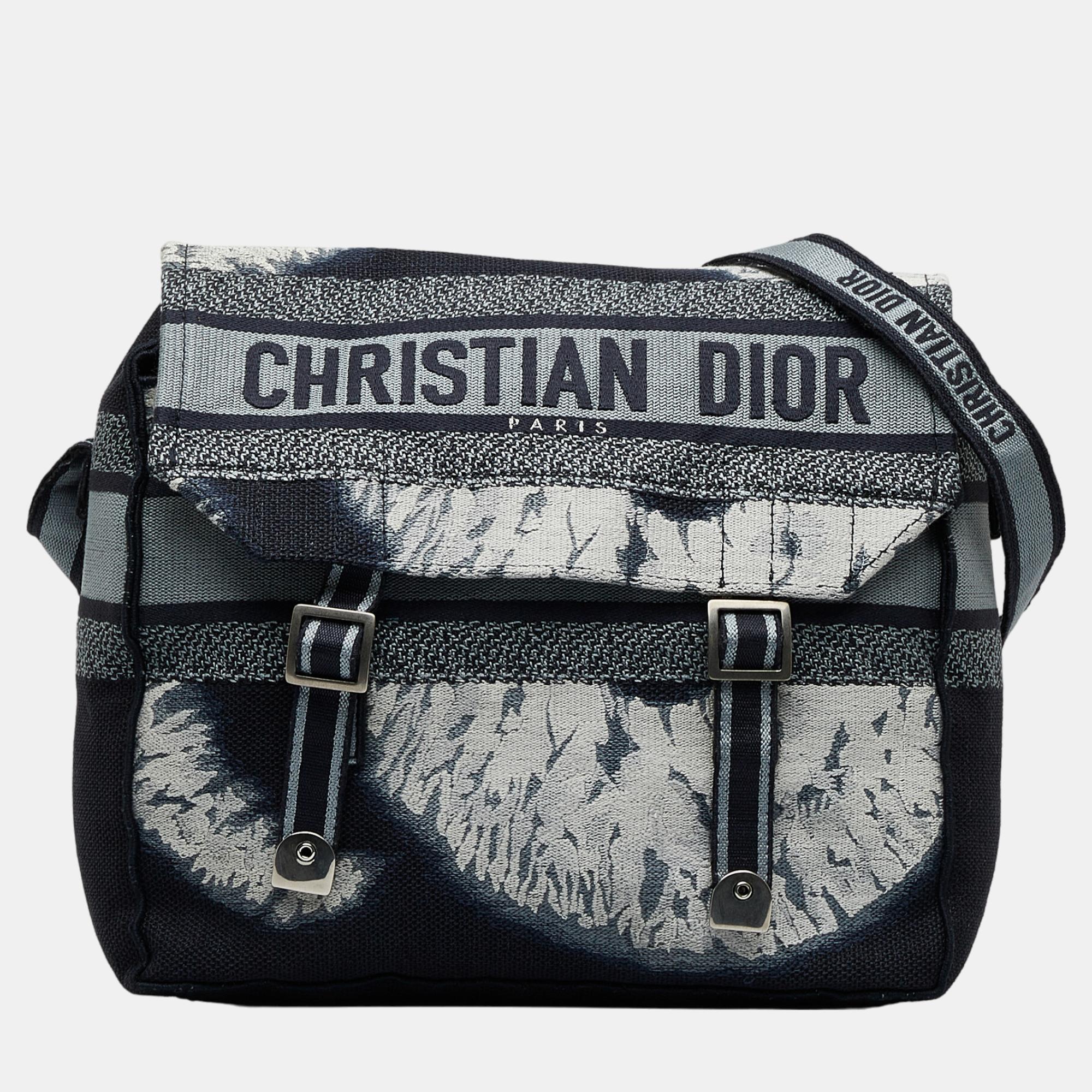 The Diorcamp messenger bag features a canvas body a flat strap a front flap and an interior slip pocket.