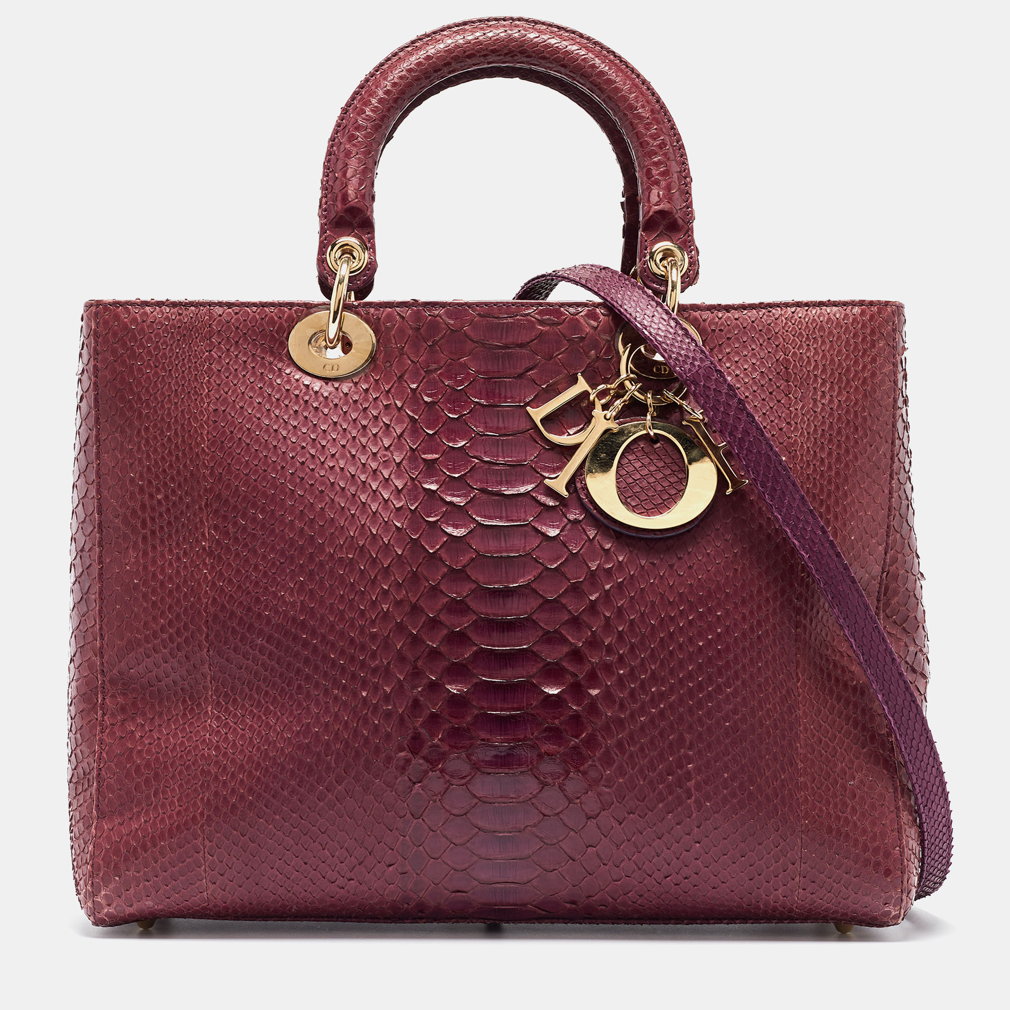 Due to detailed and innovative designs Dior has managed to be at the top of fashions hierarchy through the years. Infuse the signature aesthetics of the brand into your outfit by accessorizing it with this Lady Dior tote. With a classic design it is crafted from purple python skin and the brands letter charms mark its quality craftsmanship. The double handles at the top a shoulder strap and its perfectly sized interior make it a functional companion for your next soiree.
