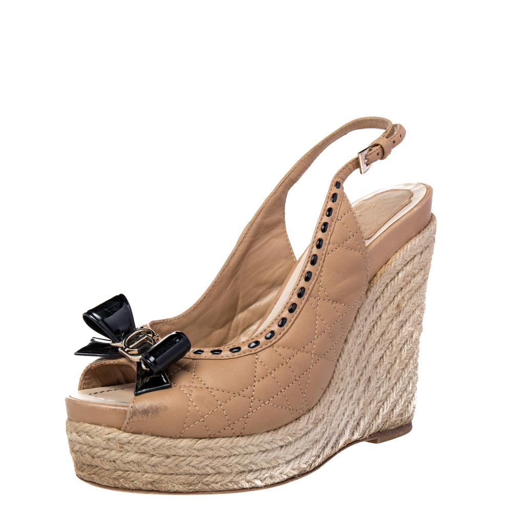 Experience comfortable luxury when you step out in this lovely pair of sandals from Dior. The pair has been designed with quilted leather and detailed with a patent bow on the uppers. The 11.5 cm wedge heels complete the standout design.